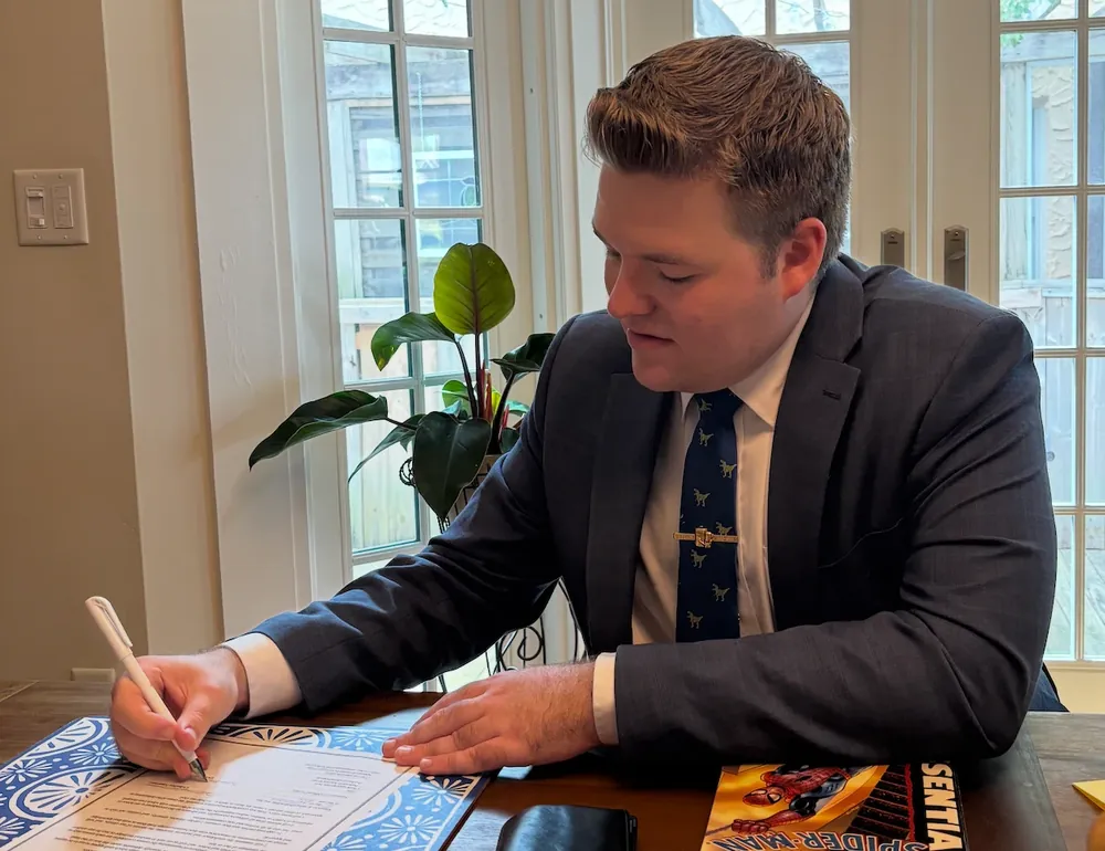 Attorney Jackson McMillan signing a document at his desk