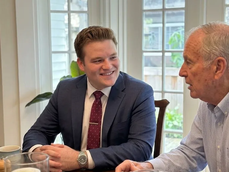 Dramatization: attorney Jackson McMillan talking with an older man at a kitchen table